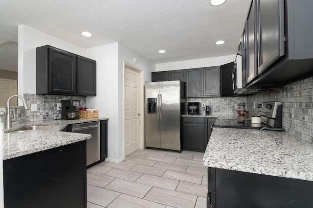 828 S Chinkapin Ave, Nixa, MO 65714 - kitchen featuring appliances with stainless steel finishes, light stone counters, tasteful backsplash, a textured ceiling, and recessed lighting