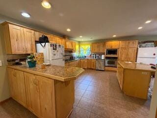 5125 S Walnut Hill Rd, Springfield, MO 65810 - kitchen with stainless steel appliances, a peninsula, recessed lighting, a kitchen bar, and light countertops