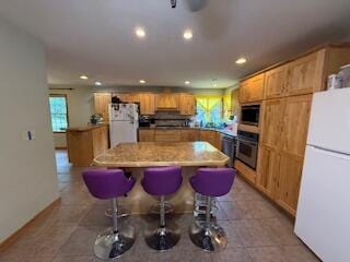 5125 S Walnut Hill Rd, Springfield, MO 65810 - kitchen featuring stainless steel appliances, a center island, recessed lighting, a kitchen breakfast bar, and light countertops