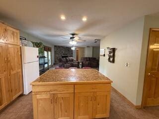 5125 S Walnut Hill Rd, Springfield, MO 65810 - kitchen featuring freestanding refrigerator, a ceiling fan, a center island, a large fireplace, and light countertops