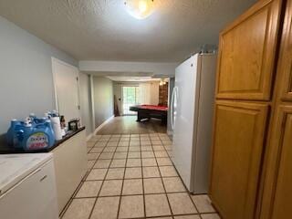 5125 S Walnut Hill Rd, Springfield, MO 65810 - corridor with a textured ceiling, light tile patterned floors, and washer / dryer