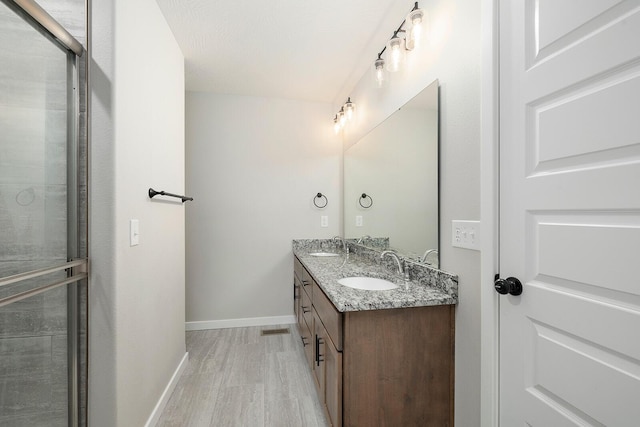 2801 E Bradford St, Republic, MO 65738 - bathroom with wood finished floors, double vanity, and a shower with door