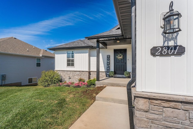 2801 E Bradford St, Republic, MO 65738 - view of exterior entry with stone siding, a yard, a shingled roof, a porch, and board and batten siding