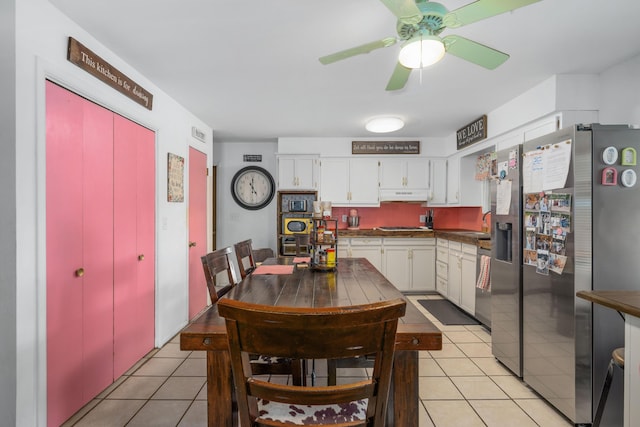 212 N School St, Goodman, MO 64843 - kitchen featuring appliances with stainless steel finishes, light tile patterned floors, under cabinet range hood, and white cabinets