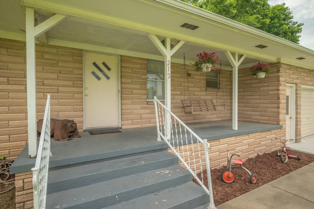 212 N School St, Goodman, MO 64843 - property entrance with a porch and brick siding