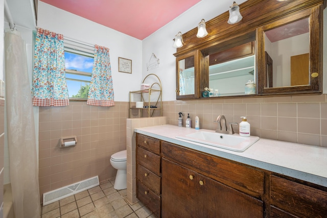 212 N School St, Goodman, MO 64843 - full bath featuring tile patterned flooring, vanity, tile walls, and wainscoting