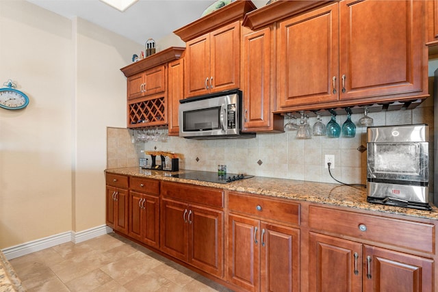215 Split Rock Dr, Hollister, MO 65672 - kitchen with stainless steel microwave, black electric cooktop, light stone counters, and backsplash