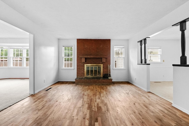 1541 E Crestview St, Springfield, MO 65804 - unfurnished living room featuring wood finished floors, plenty of natural light, and a fireplace