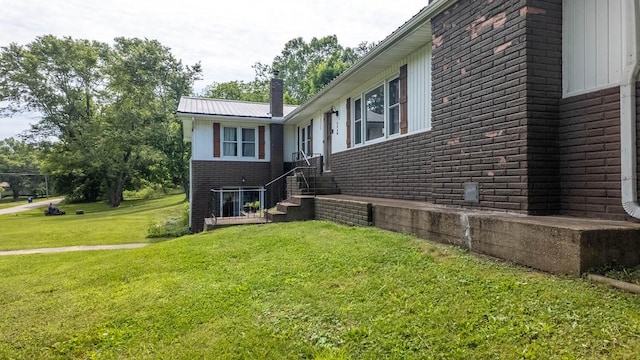 1160 Bethel Ave, Mammoth Spring, AR 72554 - view of side of home with brick siding, a chimney, and a lawn