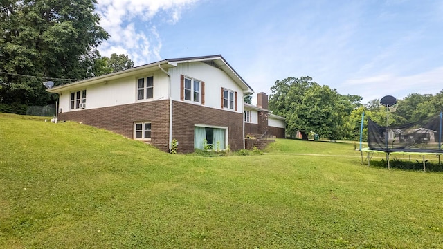 1160 Bethel Ave, Mammoth Spring, AR 72554 - view of side of home with brick siding, a trampoline, a lawn, and a chimney