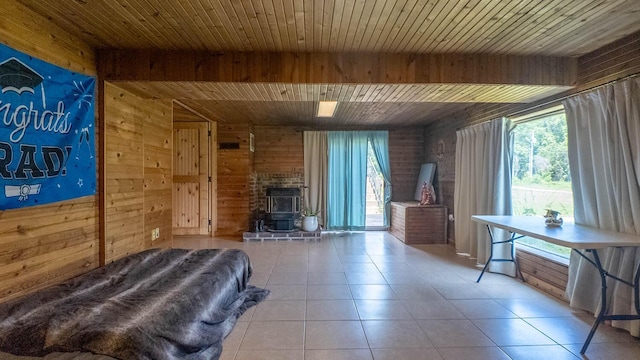 1160 Bethel Ave, Mammoth Spring, AR 72554 - tiled living area featuring a wood stove, wooden walls, and a wood ceiling with exposed beams