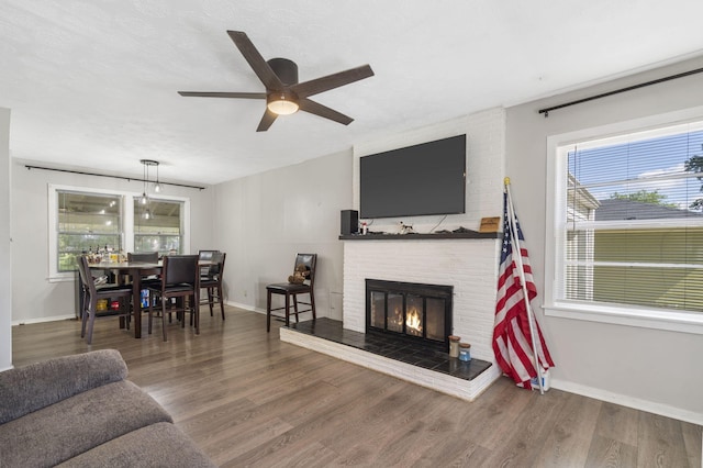 1547 S Kickapoo Ave, Springfield, MO 65804 - living room featuring a brick fireplace, a ceiling fan, and wood finished floors