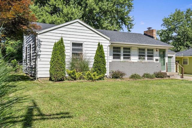 1547 S Kickapoo Ave, Springfield, MO 65804 - view of front of home with a chimney, a front yard, a shingled roof, and brick siding