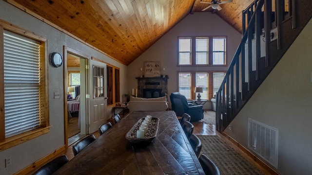 4534 Bayou Access Rd, Mammoth Spring, AR 72554 - dining room with wood ceiling, stairway, a ceiling fan, high vaulted ceiling, and a stone fireplace