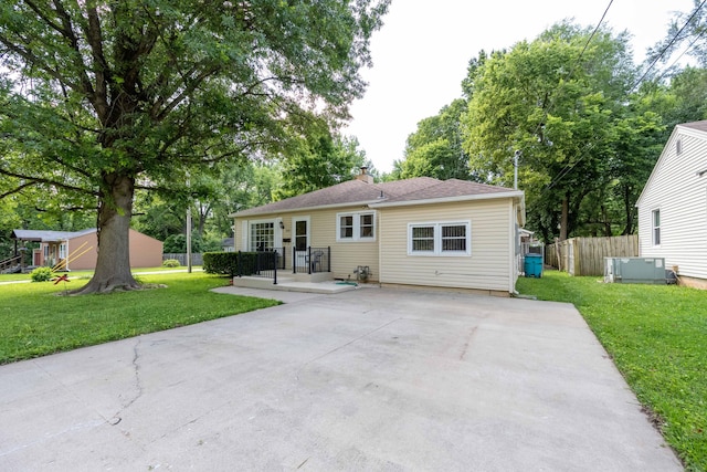 220 E Portland St, Springfield, MO 65807 - back of house featuring driveway, a chimney, and a patio