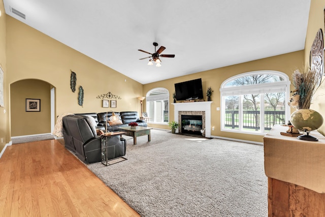 3318 Winged Foot Dr, Nixa, MO 65714 - living area with arched walkways, ceiling fan, high vaulted ceiling, a fireplace with flush hearth, and wood finished floors