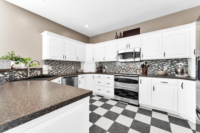 3318 Winged Foot Dr, Nixa, MO 65714 - kitchen with appliances with stainless steel finishes, dark countertops, light floors, white cabinets, and tasteful backsplash