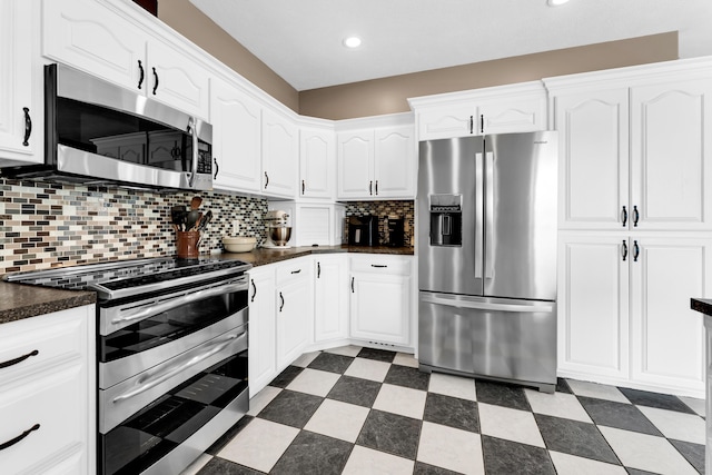 3318 Winged Foot Dr, Nixa, MO 65714 - kitchen featuring stainless steel appliances, dark countertops, white cabinetry, tasteful backsplash, and recessed lighting