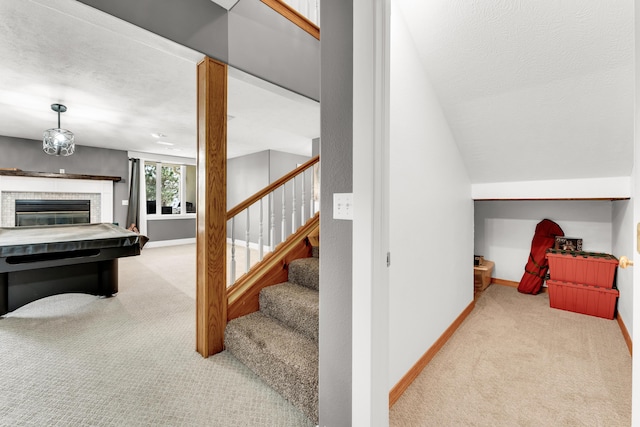3318 Winged Foot Dr, Nixa, MO 65714 - stairs featuring carpet flooring, a glass covered fireplace, and a textured ceiling