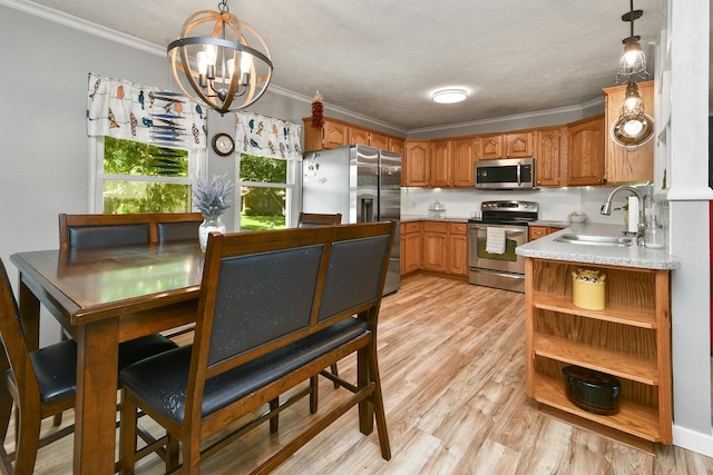 111 E Yorkshire St, Nixa, MO 65714 - kitchen with stainless steel appliances, a chandelier, brown cabinetry, light wood finished floors, and light countertops