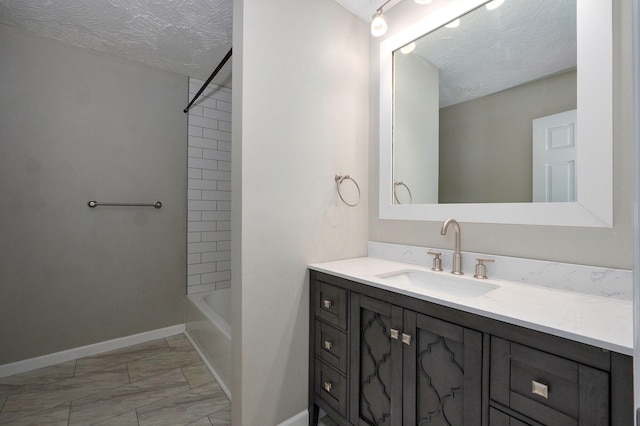 3656 S Kansas Ave, Springfield, MO 65807 - bathroom with marble look tile flooring, vanity, a textured ceiling, and shower / tub combination