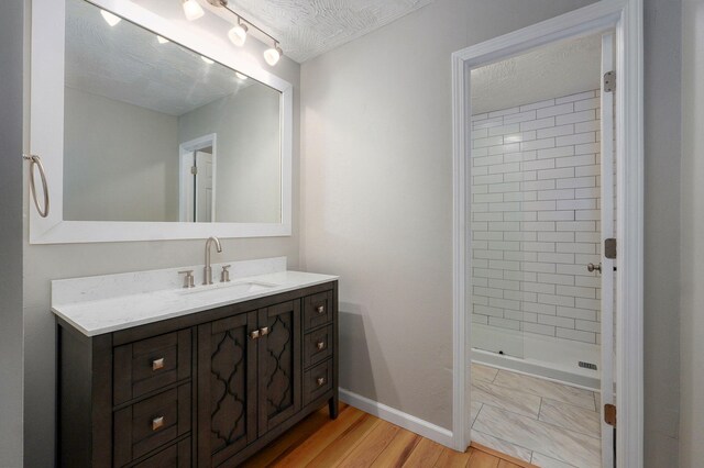 3656 S Kansas Ave, Springfield, MO 65807 - bathroom featuring vanity, a stall shower, wood finished floors, and a textured ceiling
