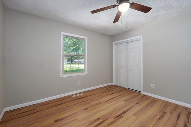 3656 S Kansas Ave, Springfield, MO 65807 - unfurnished bedroom with wood finished floors, a closet, a textured ceiling, and a ceiling fan