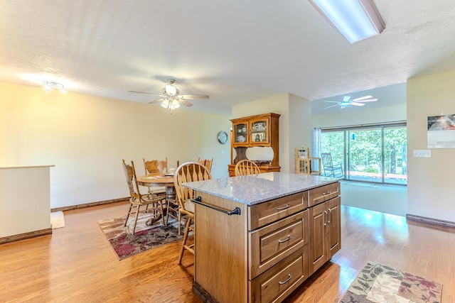 10675 State Highway Aa, Grovespring, MO 65662 - kitchen featuring a ceiling fan, light wood finished floors, and a kitchen island