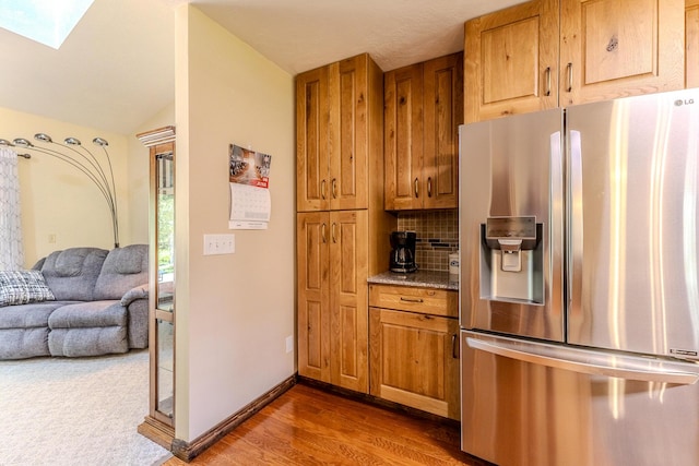10675 State Highway Aa, Grovespring, MO 65662 - kitchen featuring stainless steel fridge, wood finished floors, decorative backsplash, brown cabinetry, and vaulted ceiling