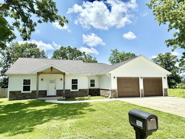 2803 Town Dr, Mountain Grove, MO 65711 - view of front facade featuring an attached garage, driveway, stone siding, and a front yard