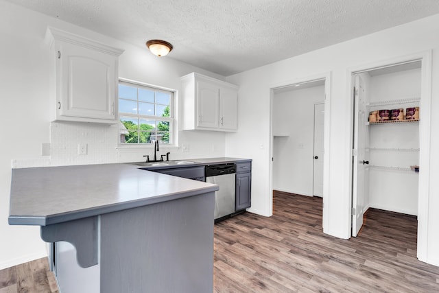 639 N Althea Ave, Nixa, MO 65714 - kitchen with dishwasher, a peninsula, white cabinets, wood finished floors, and backsplash