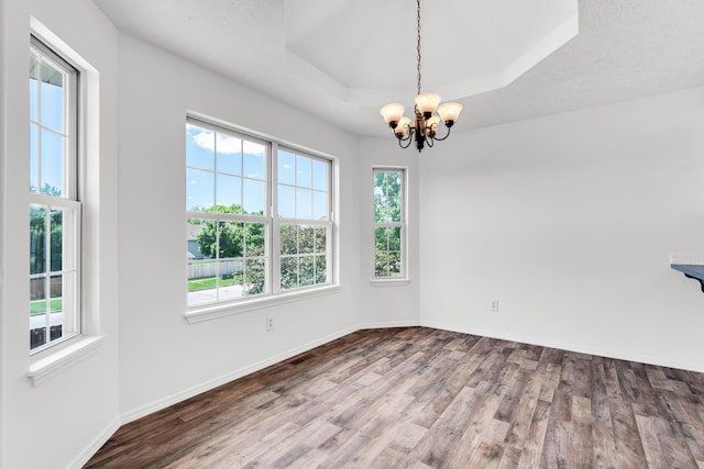 639 N Althea Ave, Nixa, MO 65714 - empty room featuring healthy amount of natural light, wood finished floors, a chandelier, and a raised ceiling