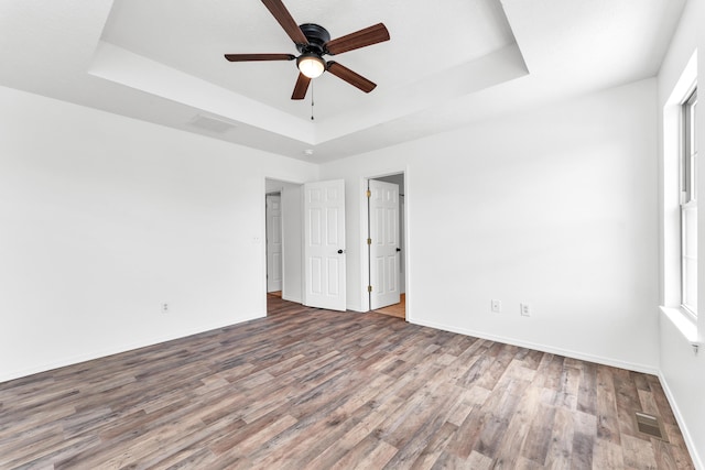 639 N Althea Ave, Nixa, MO 65714 - unfurnished bedroom featuring a raised ceiling, wood finished floors, and a ceiling fan
