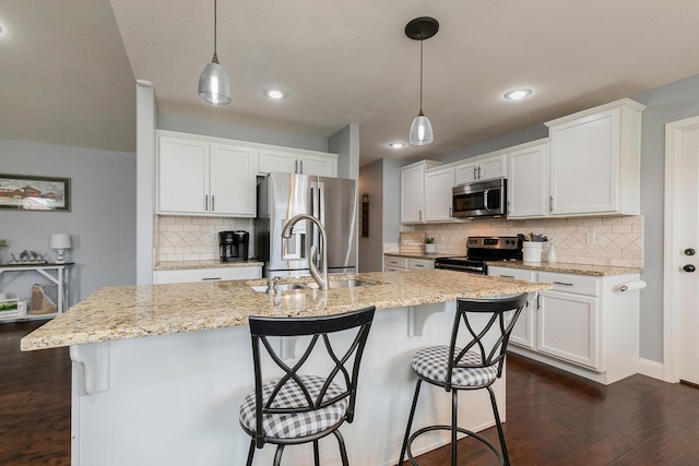 1925 E Costa Mesa Ct, Ozark, MO 65721 - kitchen with stainless steel appliances, dark wood-style floors, backsplash, a breakfast bar, and white cabinetry