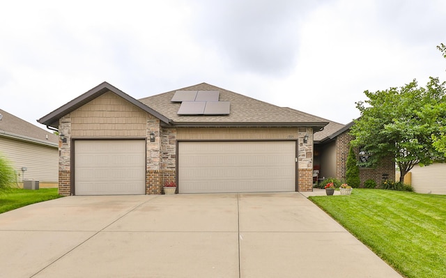 1925 E Costa Mesa Ct, Ozark, MO 65721 - view of front of property with solar panels, a front yard, an attached garage, brick siding, and roof with shingles