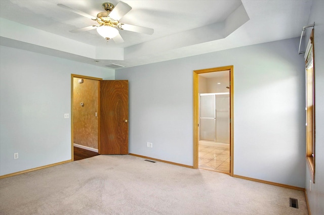 4939 S Prairie View Ave, Battlefield, MO 65619 - unfurnished bedroom with carpet floors, connected bathroom, a raised ceiling, and ceiling fan