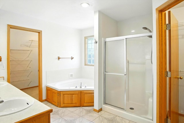 4939 S Prairie View Ave, Battlefield, MO 65619 - full bathroom featuring a shower stall, a bath, a walk in closet, double vanity, and tile patterned flooring