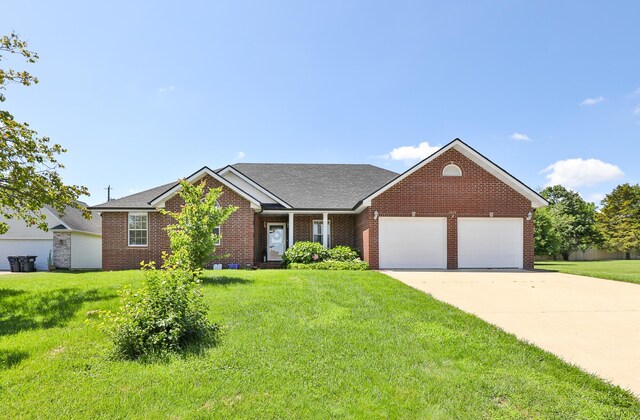 1020 Berkley Dr, Marshfield, MO 65706 - view of front facade with an attached garage, brick siding, a front lawn, driveway, and roof with shingles