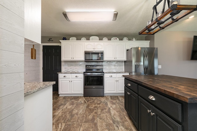 1020 Berkley Dr, Marshfield, MO 65706 - kitchen featuring stainless steel appliances, white cabinets, wooden counters, and backsplash