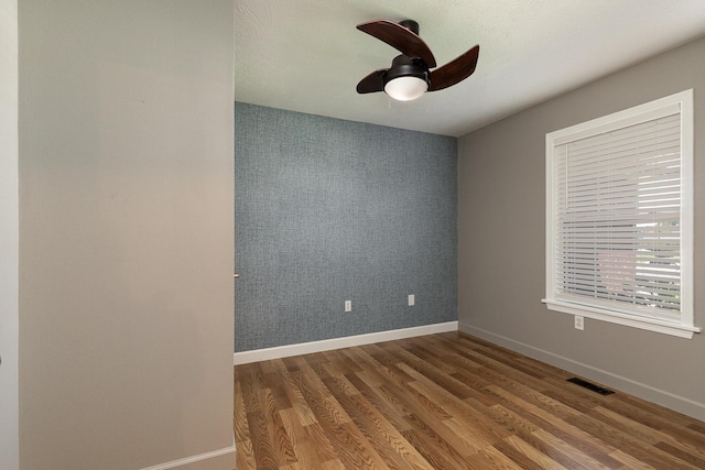 1020 Berkley Dr, Marshfield, MO 65706 - unfurnished room with wood finished floors, an accent wall, and ceiling fan