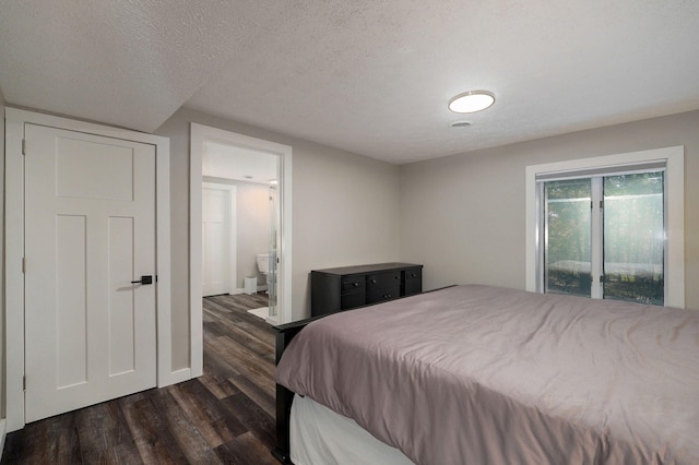199 Cardinal Rd, Hollister, MO 65672 - bedroom with dark wood finished floors, ensuite bath, access to exterior, and a textured ceiling