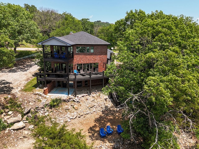 199 Cardinal Rd, Hollister, MO 65672 - rear view of house featuring brick siding, a deck, a balcony, a view of trees, and a patio