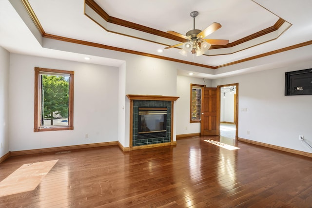 2661 E Ridgewood Dr, Springfield, MO 65804 - unfurnished living room featuring a raised ceiling, ornamental molding, a tile fireplace, hardwood / wood-style floors, and a ceiling fan