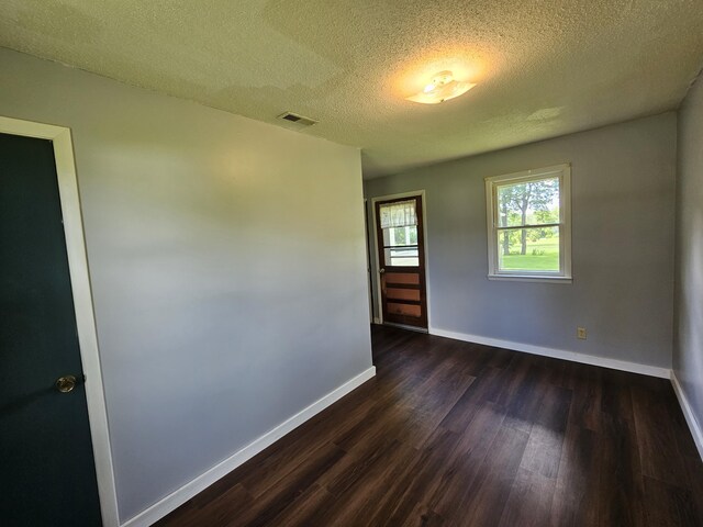 1713 Wall Rd, Mountain Grove, MO 65711 - spare room featuring dark wood-type flooring and a textured ceiling