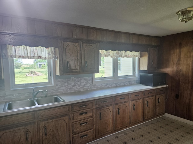 1713 Wall Rd, Mountain Grove, MO 65711 - kitchen with healthy amount of natural light, wooden walls, brown cabinetry, black microwave, and light countertops