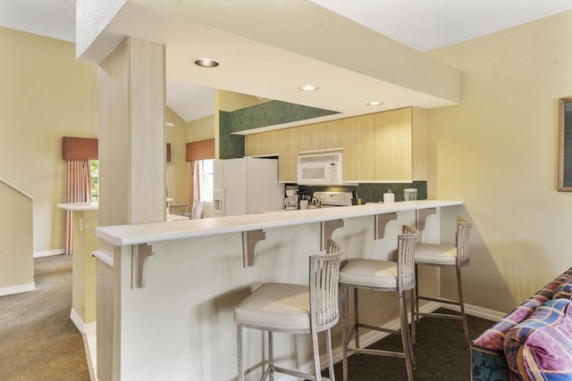 2800 Green Mountain Dr Unit 130A & D, Branson, MO 65616 - kitchen with white appliances, light brown cabinetry, carpet flooring, a breakfast bar, and a peninsula