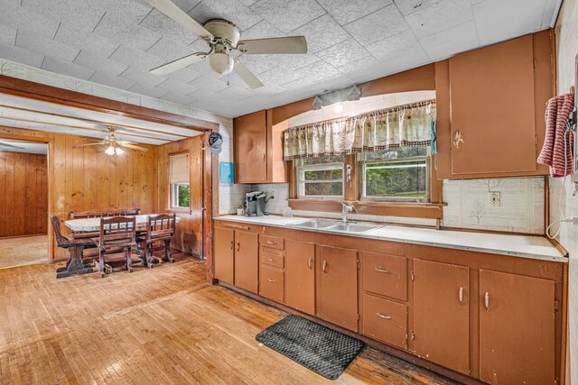 1215 Lanton Rd, West Plains, MO 65775 - kitchen featuring ceiling fan, light countertops, light wood-style flooring, backsplash, and wood walls