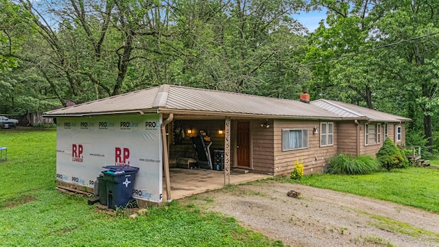 1215 Lanton Rd, West Plains, MO 65775 - view of front facade featuring a metal roof, a chimney, a front yard, dirt driveway, and a forest view
