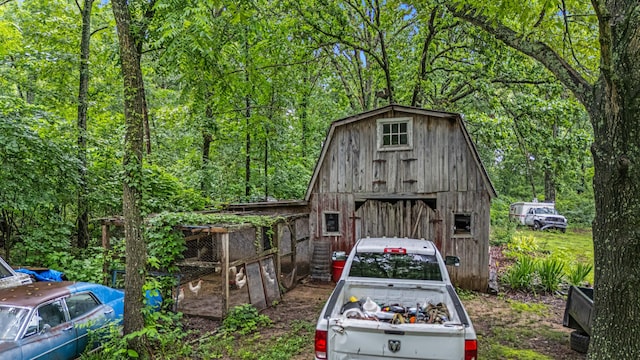 1215 Lanton Rd, West Plains, MO 65775 - view of front of house with an outdoor structure, a forest view, and a barn