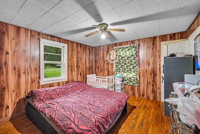 1215 Lanton Rd, West Plains, MO 65775 - bedroom featuring wooden walls, hardwood / wood-style flooring, and a ceiling fan